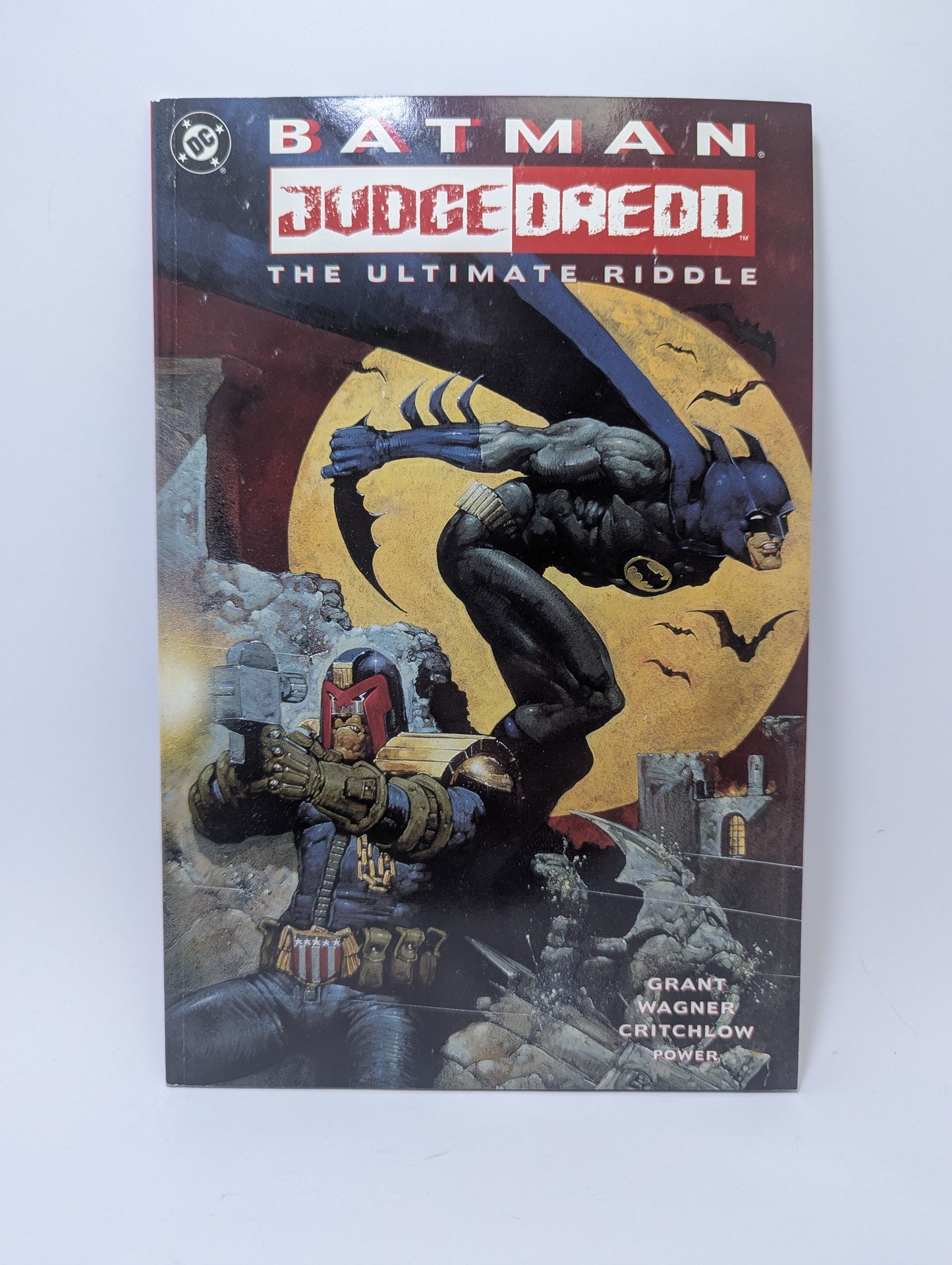 Grafinės novelės Batman - Judge Dredd: The Ultimate Riddle viršelis, kuriame pavaizduoti abu herojai.