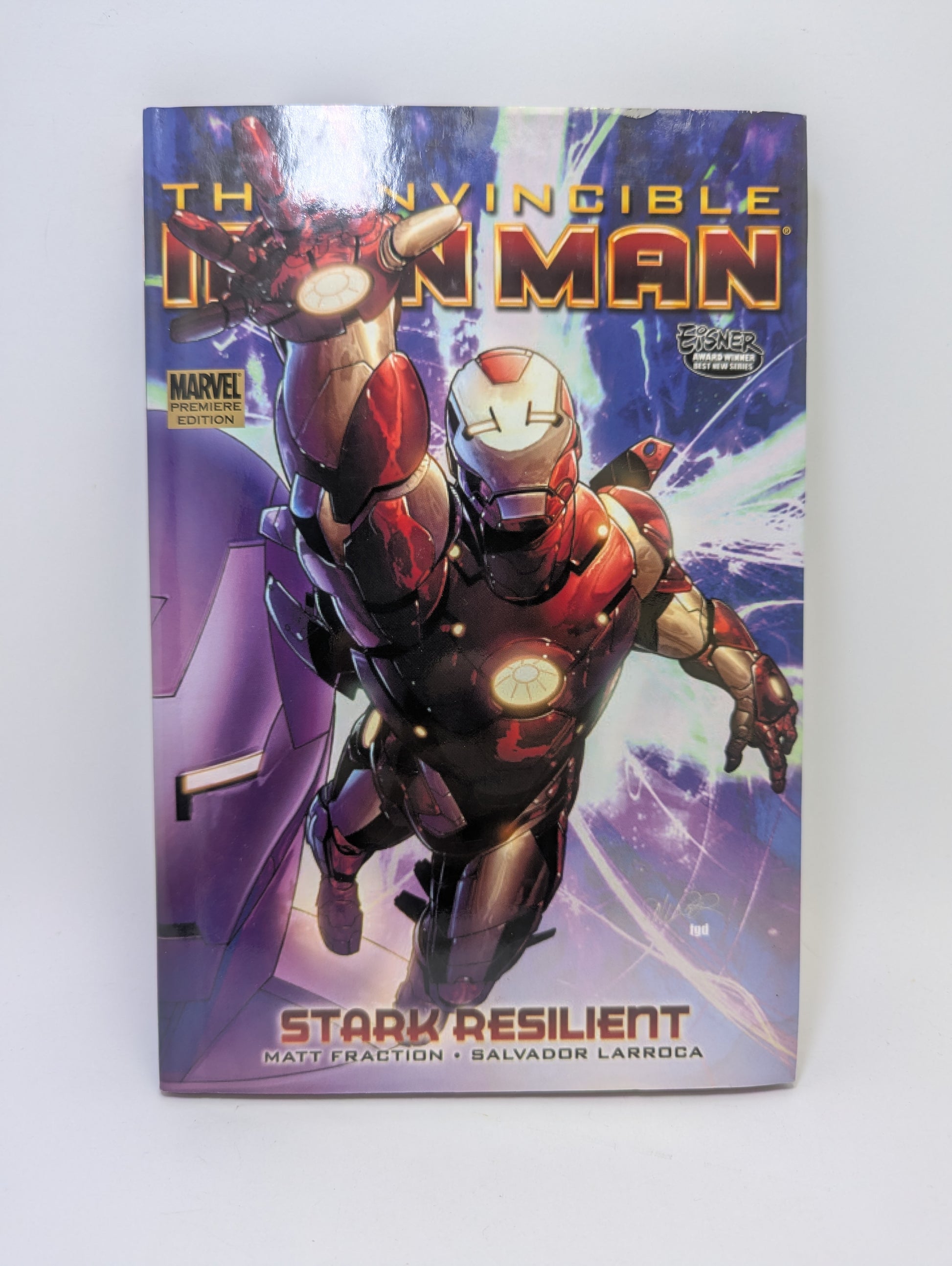 Grafinė novelė „Invincible Iron Man, Volume 5: Stark Resilient, Book 1“ su Tony Starku ir futuristiniu „Iron Man“ šarvų dizainu ant viršelio.