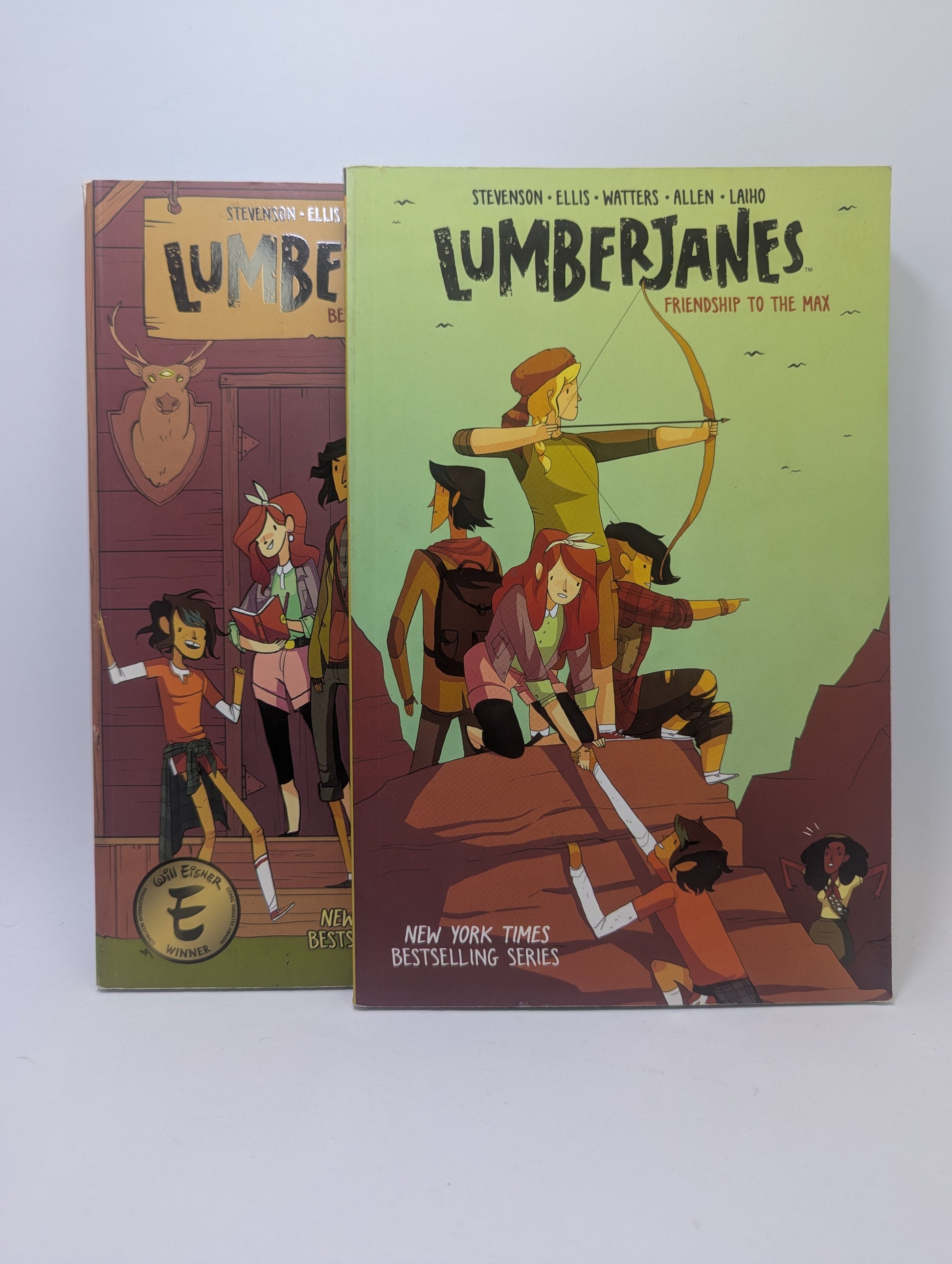 „Lumberjanes“ pirmųjų dviejų tomų viršeliai su pagrindinėmis herojėmis stovyklos fone.