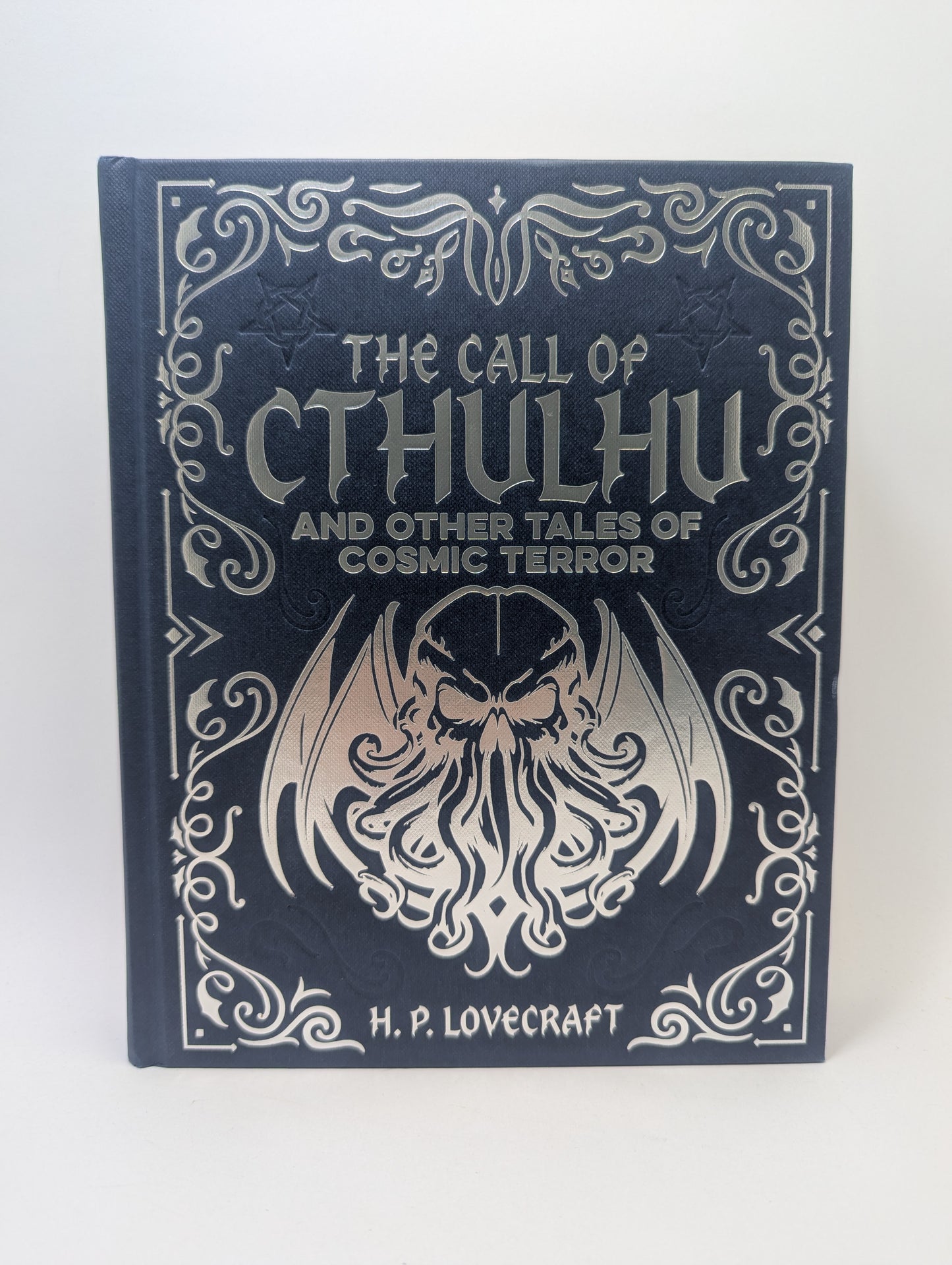 Anglų kalba išleista knyga „The Call of Cthulhu and Other Tales of Cosmic Terror“ su tamsaus, kosminio siaubo stiliaus viršeliu.