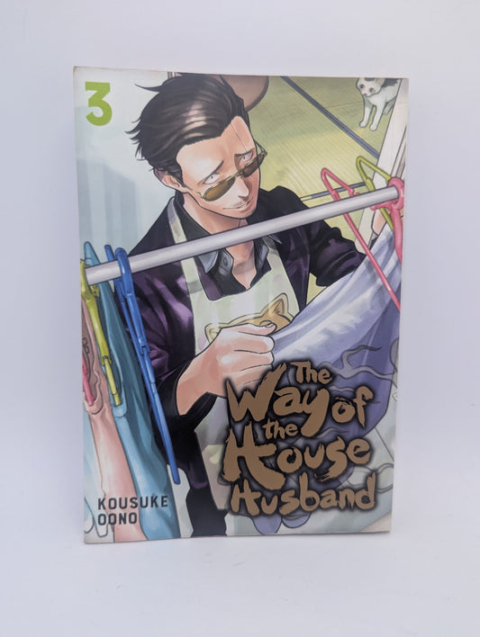 Mangos The Way of the Househusband 3-ojo tomo viršelis su prijuostę dėvinčiu Tatsu.