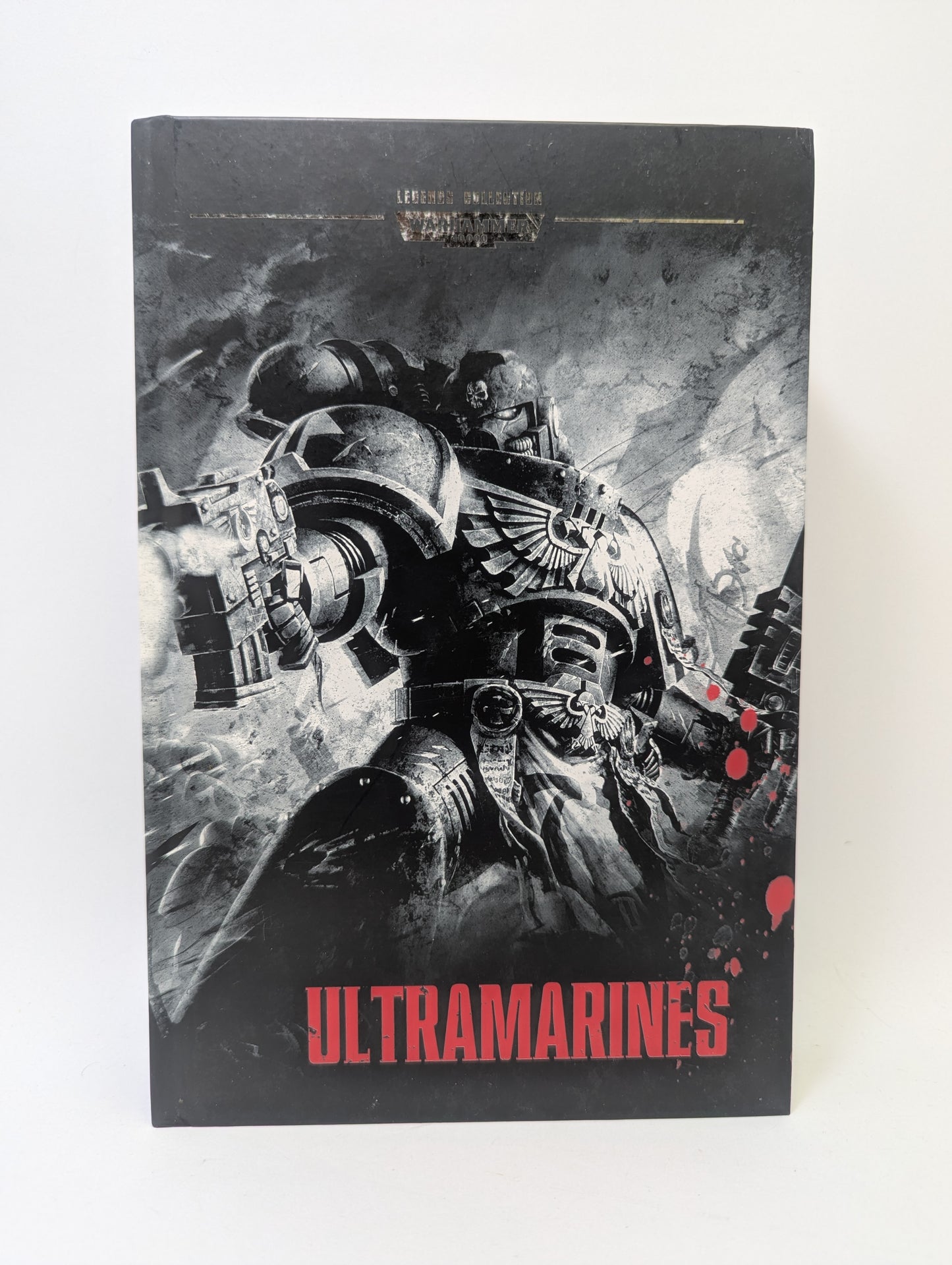 Warhammer 40K knyga „Legends Collection Book 5 – Ultramarines“ su Ultramarines Space Marines ir grimdark mokslinės fantastikos viršelio dizainu.